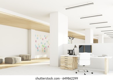 Office interior with a computer standing on a desk, light wooden floor, columns and a white wall with sticky notes. 3d rendering, mock up
