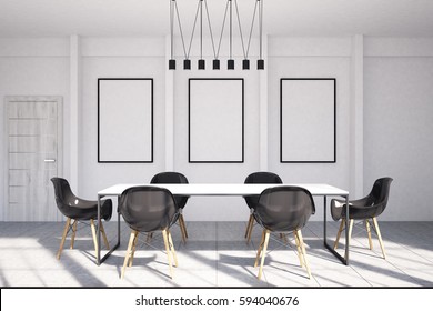 Office Meeting Room Interior With Three Framed Vertical Posters Hanging On A White Wall, A Row Of Ceiling Lights And A Table Surrounded By Black Armchairs. 3d Rendering, Mock Up