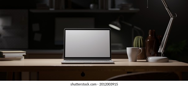 Office At Night, Dark Work Space, Blank Screen Laptop Mock Up On Wooden Desk With Light From Table Lamp, Decor And Blurred Office Interior In Background, 3d Rendering, 3d Illustration