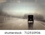 Old Jalopy Driving Down a Wet Highway