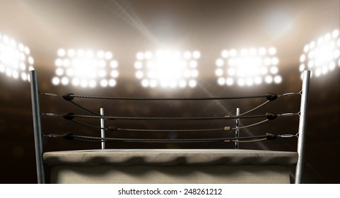 An Old Vintage Boxing Ring Surrounded By Ropes Spotlit By Floodlights In An Arena Setting At Night