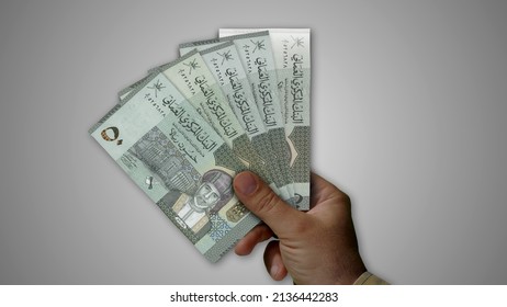 Oman Rial Pile Of Money In Hand 3d Illustration. OMR Banknotes Background Concept Of Finance, Economy Crisis, Inflation And Business.