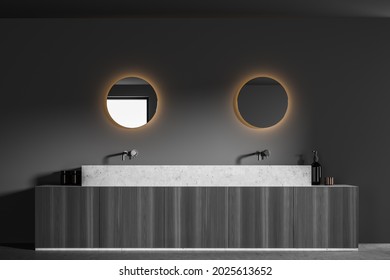 On Trend Round Mirrors On The Wall Of Dark Grey Bathroom Interior With Floating Sink. Design, Using Two Faucets And Dark Wood Vanity. A Concept Of A Modern House. 3d Rendering