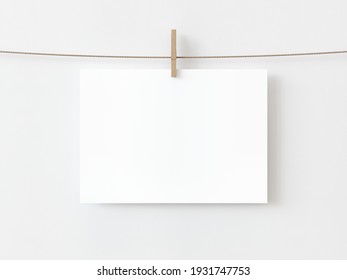 One Blank Horizontal Rectangle Note Paper Card Hanging With Wooden Clip Or Clothespin On Rope String Peg Isolated On White Backgroun. 3D Illustration