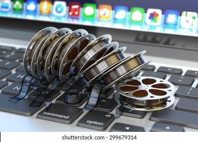 Online movies cinema concept, internet video and  multimedia content, stack of film reels on computer laptop keyboard