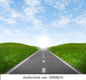 Offene Straße mit grünem Gras und blauem Himmel mit einer asphaltierten Straße, die das Konzept der Reise zu einem fokussierten Ziel darstellt, das zu Erfolg und Glück führt.