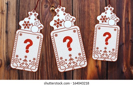 Ornamental 3d Rendered Christmas Labels With Question Sticker In Front Of A Nice Wooden Background