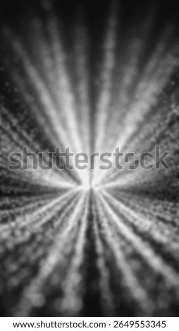 Out of focus abstract light rays emanating from a central bright point against dark background