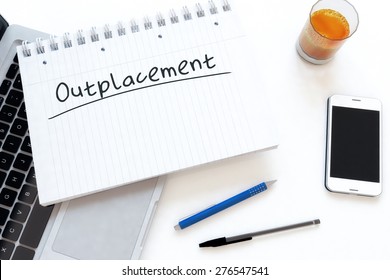 Outplacement - handwritten text in a notebook on a desk - 3d render illustration.