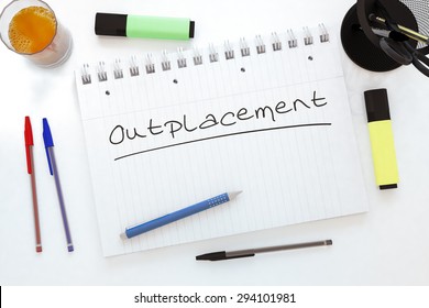 Outplacement - handwritten text in a notebook on a desk - 3d render illustration.