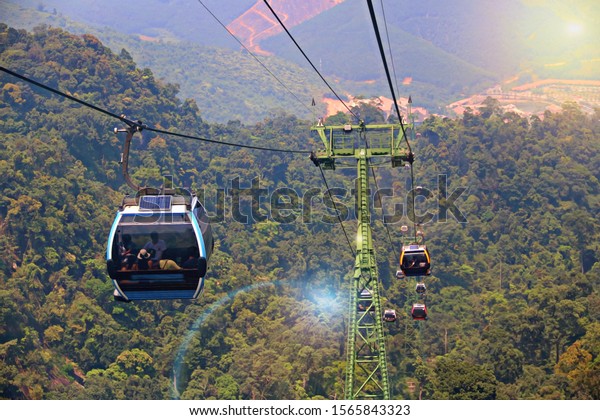 Overhead Cable Car hanging and moving on cable\
lines of Skybridge over forest which on mountain. ILLUSTRATION ASIA\
TRAVEL CONCEPT. Transportation in natural landscape areas of Ba Na\
Hills, Vietnam.