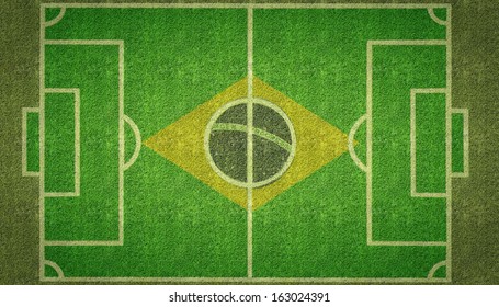 An Overhead View Of A Football Soccer Pitch With White Markings And The Flag Of Brazil Painted On Grass.
