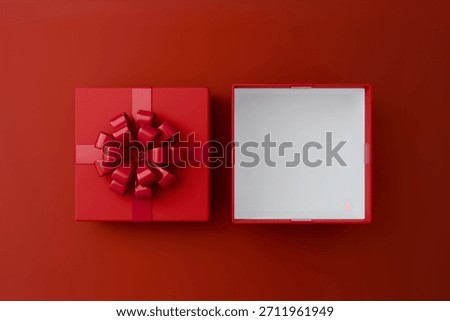 Overhead view of a separate red gift box lid with a fancy bow and the main empty box with a white interior, all on a red surface.