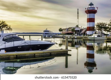 Painterly waterscape of marina and lighthouse near sunset on Hilton Head Island, South Carolina, USA, with digital painting effect, for coastal, marine and travel themes