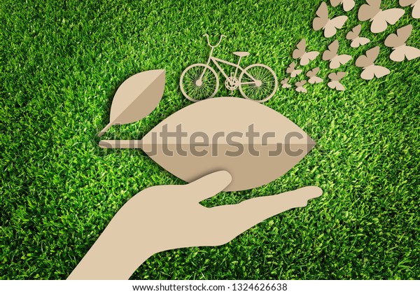 Paper art\
style of eco concept on green grass background. Eco bicycle. Go\
green concept. Car free day. Save the\
earth.