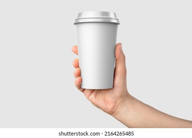 Paper coffee cup with plastic cap in a hand mockup template, isolated on light grey background. High  resolution 3D illustration. - Powered by Shutterstock