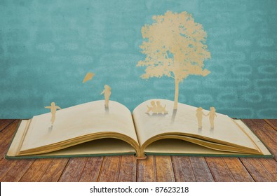 Paper Cut Of Children Play  On Old Book