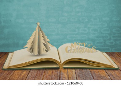 Paper Cut Of Christmas Tree On Old Book