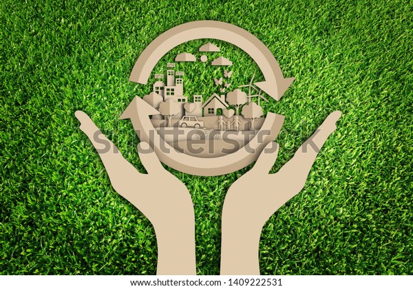 Paper cut of eco concept on green grass\
background. Eco friendly. Save the\
earth.