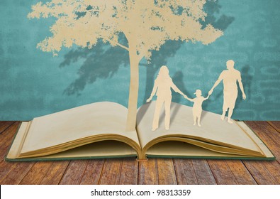 Paper Cut Of Family Symbol Under Tree On Old Book