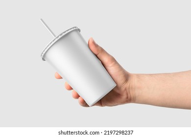 Paper Soda Cup In A Hand With Straw Mockup Template, Isolated On Light Grey Background. High Resolution 3D Illustration.