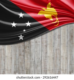 Papua New Guinea flag of silk with copyspace for your text or images and wood background