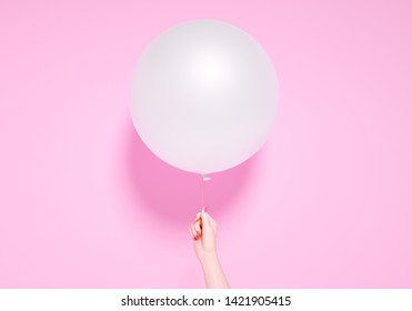 Party banner, celebration birthday or anniversary concept. One round balloon and hand holding it on pink background, 3d illustration
