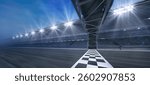 Passing Finish line on a race track with metal gate construction and floodlights illuminating sports racing stadium.