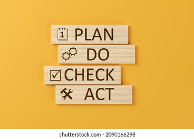 PDCA, plan - do - check - act, schema on wooden blocks over orange background, business or quality control strategy concept, 3D illustration