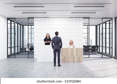 People Are Standing In An Office Lobby. Large Wall Is Decorated With White Tiles. There Is A Wooden Part Of It And Two Conference Rooms By Both Sides. 3d Rendering. Mock Up