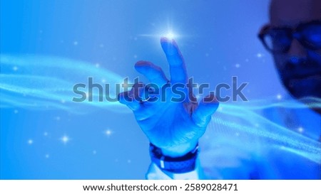 A person interacts with a digital interface, touching a glowing point. The scene is bathed in blue light, creating a futuristic and technological atmosphere.