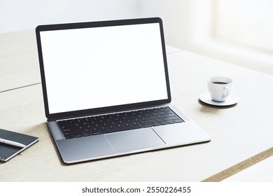 Perspective view on blank white modern laptop monitor with copyspace for your logo or text on light wooden table with coffee mug in sunny office area. 3D rendering, mock up