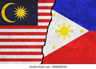 Philippines and Malaysia painted flags on a wall with a crack. Philippines and Malaysia conflict. Malaysia and Philippines flags together. Philippines vs Malaysia