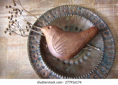 Picture Of Authentic National Clay Whistle On The Antique Copper Plates Background  In Ethnic Vintage Style. Ancient Clay Musical Instrument.