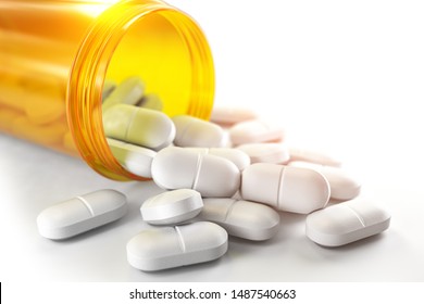 Pills Spilling Out Of Pill Bottle Isolated On White. Medicine And Pharmacy Concept. 3d Illustration