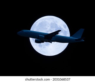 plane flying in front of the full moon. horizontal banner on black