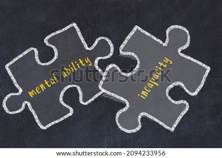 Ploblem solving. Chalk sketch of two puzzles with words mental ability and incapacity on black chalkboard