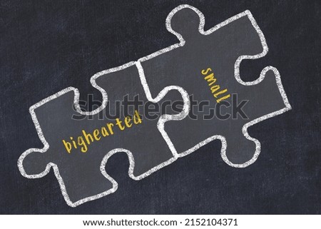 Ploblem solving. Chalk sketch of two puzzles with words bighearted and small on black chalkboard