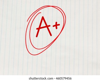 A Plus (A+) Grade Written In Red On Notebook Paper