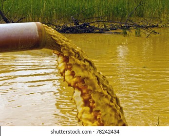 Polluted dirty water stems from the pipe into the river