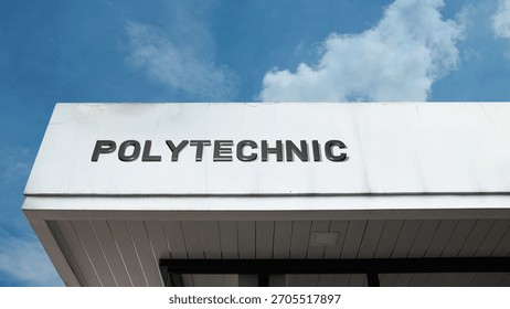 "Polytechnic" sign on an educational building against a clear blue sky, symbolizing technical education, applied sciences, engineering, vocational training, and skilled career preparation