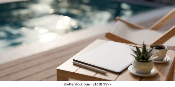 A Portable Tablet Mockup Is On A Wooden Outdoor Side Table Over Blurred Swimming Pool With A Beach Chair On Wooden Patio In Background. Close-up Image. 3d Rendering, 3d Illustration