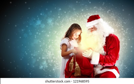 Portrait of Santa Claus with a little girl looking at a gift - Powered by Shutterstock