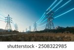 Power Transmission Lines. Clean Ecological Environment. High voltage steel power pylons in field. Transmission of electricity through high-voltage wires