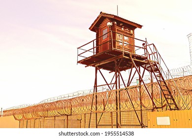Prison tower and barbed wire fence. Wooden tower with room for guard of prisoners in pre-trial detention center or prison zone