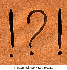 question marks and exclamation mark painted in watercolor on Kraft paper