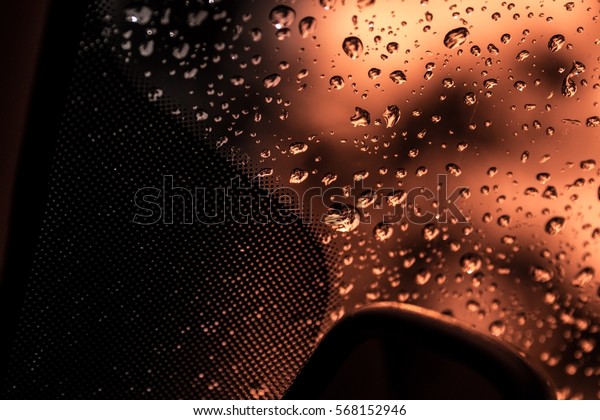 Rain water on car window, shoot from the inside of\
the car, location in the car, front windscreen just above the\
review mirror