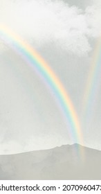 Rainbow over mountains background with clouds