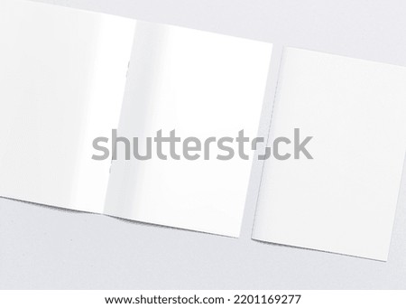 Realistic top view cover and opened portrait A4 or A5 magazine or brochure booklet for stationery and branding. Mockup template isolated light grey background and leaf shadow overlay. 3D rendering.