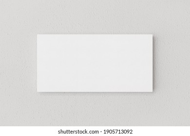 Rectangular blank canvas of 2x1 proportions to present artwork, illustrations or photos hanging on a white wall. 3D Rendering